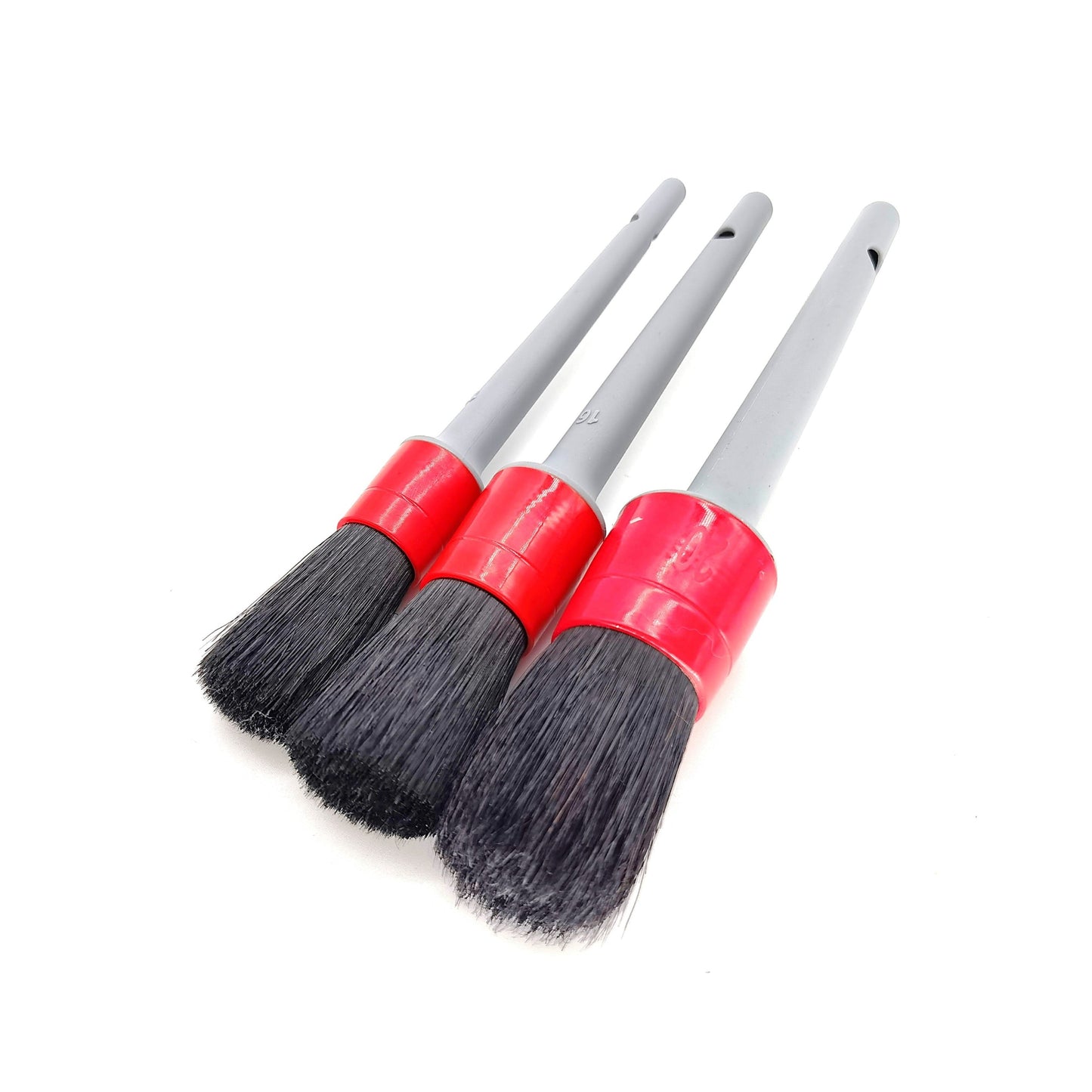 Three cleaning brushes with red handles and black bristles on a white background